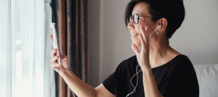A person who is visibly happy and is having a video call on their phone.
