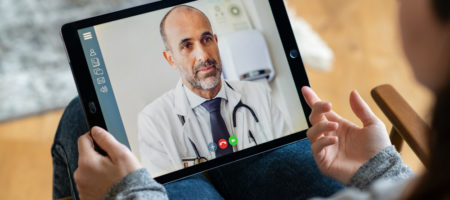 A person having a video consultation with their doctor via a video chat on their iPad.