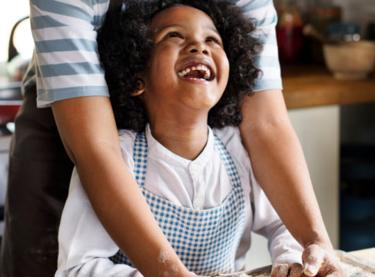 A mother and child baking with flour.