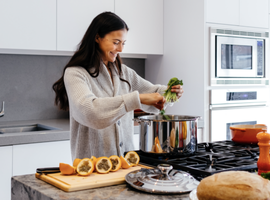person cooking healthy food at the stove in their kitchen.