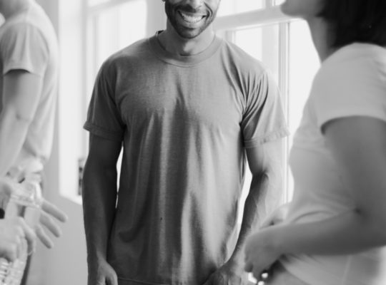 Two people in a hallway smiling at each other