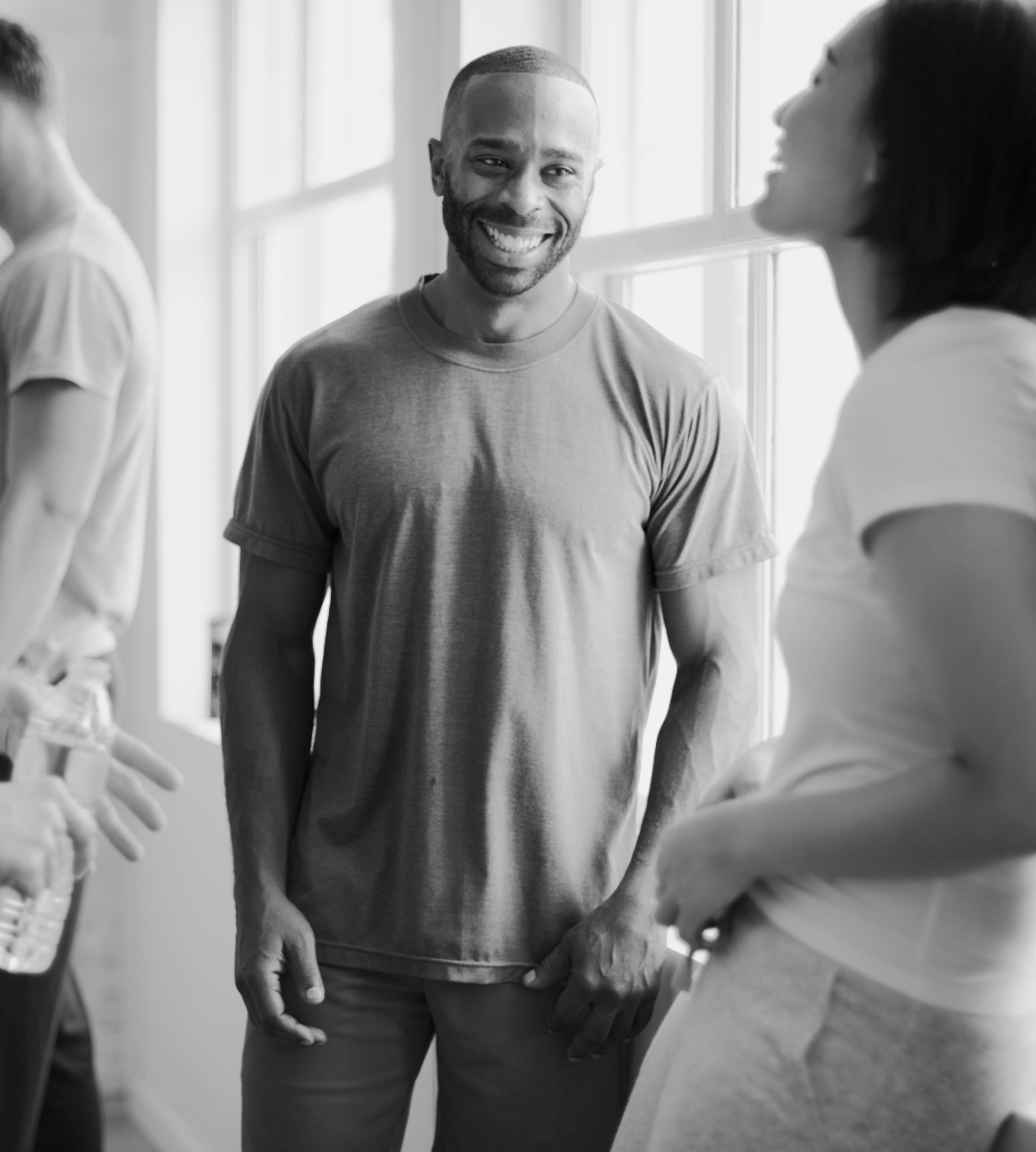 Two people in a hallway smiling at each other