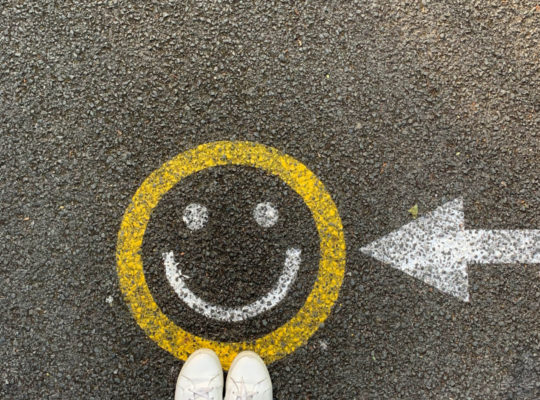 A happy face painted onto a sidewalk