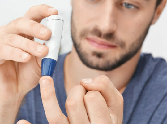 A person using a glucose meter on their finger to check blood sugar levels.