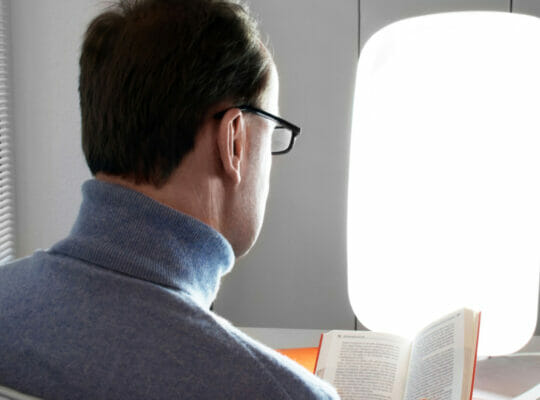 person staring down at their book.